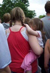 [Woman carrying a small girl (age approx. 3)]