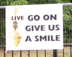 [Sign saying 'Go on, give us a smile']